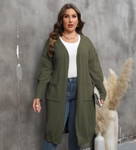Détail du cardigan en maille vert armée avec manches ballon et grandes poches avant