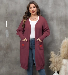 Detail of red knit cardigan with heart embroidery on front pockets and long sleeves