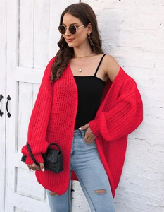 Detail view of red chunky knit cardigan with ribbed cuffs and textured weave style