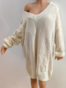 Detailed close-up of beige cable knit texture and deep V-neckline on oversized dress