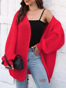 Detail of red oversized knit cardigan featuring thick wave texture and slouchy loose fit