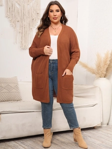 Detail of oversized rust brown batwing sleeve cardigan with large pockets and knit texture