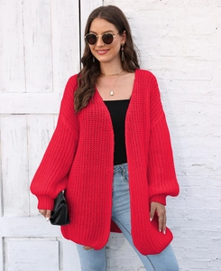 Detail of red chunky knit cardigan featuring oversized lantern sleeves and cozy texture