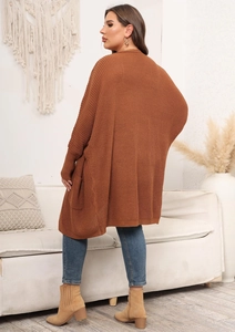 Detailed close-up of a loose caramel knit cardigan showing large pocket and sleeve texture