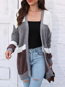 Close-up of color-block knit cardigan texture with white, grey, and brown striped pattern