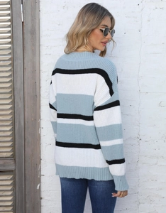Detail view showing ribbed cuffs and striped knit pattern on women's V-neck sweater