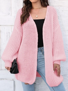 Detail of pink chunky knit cardigan showing thick texture and ribbed cuffs on sleeves