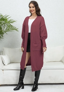 Close-up of a burgundy knit cardigan featuring large side pockets and ribbed cuffs