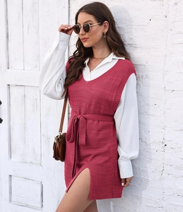 Detail of knit vest dress with V-neck, side slits, and adjustable waist tie in magenta