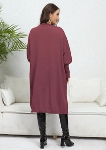 Rear view of loose knit cardigan in burgundy with ribbed lantern sleeves and boots