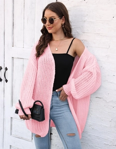 Detailed macro view of the soft pink chunky knit texture on a loose open cardigan sweater