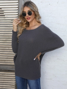 Dettaglio di un maglione a maglia grigio scuro con texture a costine spesse e maniche a pipistrello