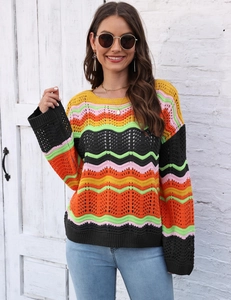 Detailed view of colorful zigzag knit pattern and crochet hollow texture on the sweater
