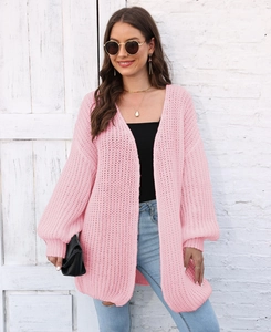 Detail of pink knit cardigan featuring lantern sleeves and loose casual texture
