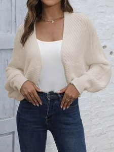 Close-up of beige chunky knit cardigan with ribbed texture and loose batwing sleeves