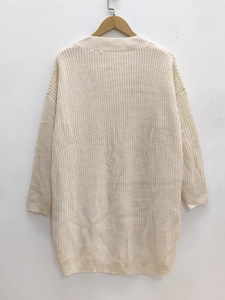 Detailed close-up of cream chunky knit texture and ribbed pattern on loose midi dress