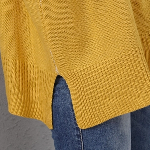 Close-up of mustard yellow knit sweater with ribbed hem and stylish side slit detail