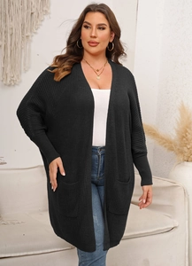 Detail of black waffle knit cardigan featuring oversized side pockets and a relaxed batwing sleeve
