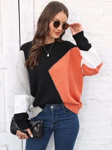 Dettaglio di maglione in maglia color-block con pannelli arancioni e grigi autunnali