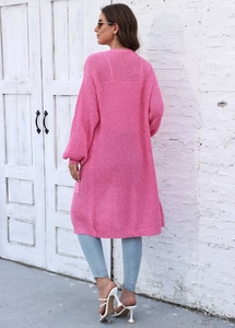 Vista posteriore del lungo cardigan in maglia rosa con trama spessa e polsini