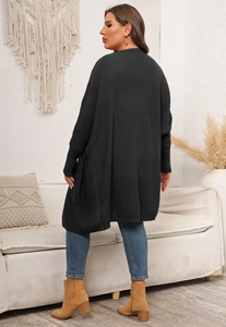 Detail showing charcoal grey chunky knit cardigan with relaxed batwing sleeves and pockets