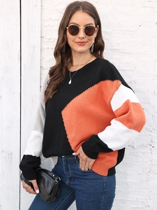 Dettaglio della trama del maglione in maglia color-block con pannelli arancioni