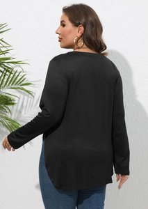 Détail du haut noir à manches longues avec ourlet arrondi asymétrique et fente latérale