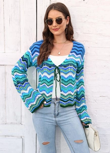 Detail of colorful rainbow wavy knit cardigan featuring front tie closure and long sleeves