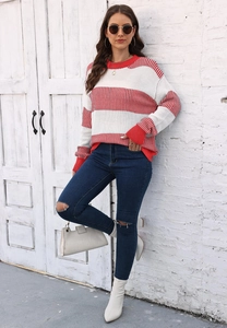 Photo de rue d'une femme portant un pull en maille à rayures rouges et blanches et un jean troué