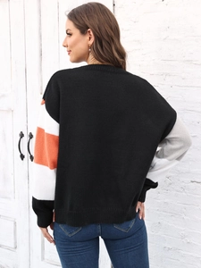 Dettaglio maglione in maglia color-block con strisce arancioni e bianche sulla manica