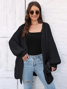 Close-up of black oversized knit cardigan featuring balloon sleeves and casual loose fit