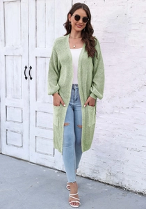 Dettaglio del cardigan in maglia verde chiaro con ampie tasche e trama a coste