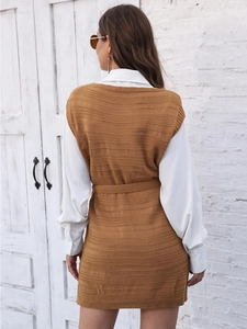 Detail of a brown knitted long vest featuring a matching belt and side slit texture