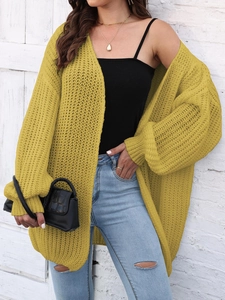 Detail of chunky knit yellow cardigan showing the loose texture and balloon sleeves