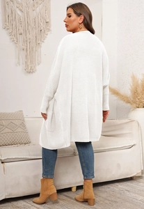 Detail of white oversized knit cardigan featuring batwing sleeves and functional side pockets