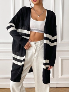 Detail showing the long sleeve cuffs with bold white contrast stripes on a black knit cardigan
