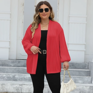 Detail view of red oversized pleated cardigan with lantern sleeves and textured fabric