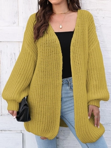 Close-up of mustard yellow chunky knit cardigan featuring textured knit and puff sleeves