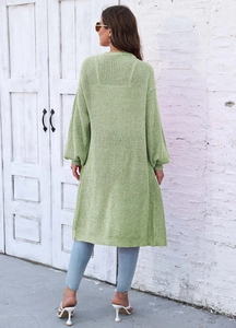 Dettaglio del retro di un cardigan in maglia verde chiaro con maniche a lanterna e trama spessa