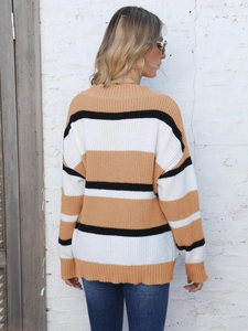 Detail of loose fit knit sweater with horizontal stripes in brown white and black