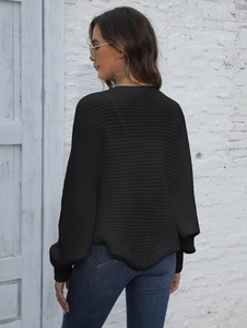 Close-up of black knit cardigan featuring ribbed texture and batwing sleeve design