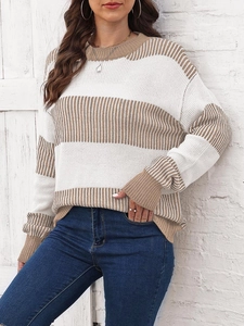 Détail d'un pull en maille ample avec des rayures horizontales marron et blanc
