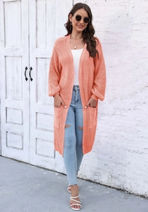 Dettaglio del cardigan lungo in maglia arancio corallo con tasche grandi e maniche a palloncino