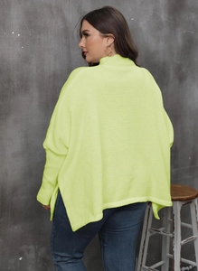 Detail of oversized neon yellow turtleneck sweater with high side slits and batwing sleeves