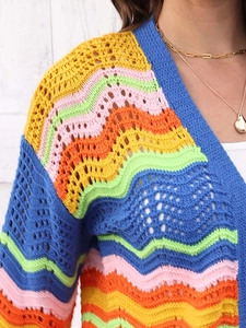 Detail of colorful crochet knit cardigan with bohemian rainbow wave pattern and hollow texture