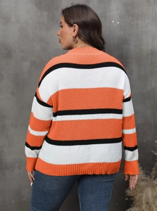 Detail shot of oversized knit sweater with vibrant orange and black horizontal stripes