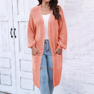 Dettaglio del cardigan lungo arancione a maglia grossa con tasche laterali e trama morbida