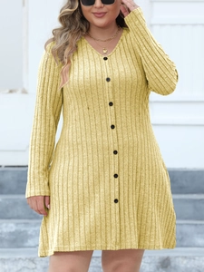 Détail de robe en maille jaune avec décolleté en V profond et boutons noirs décoratifs
