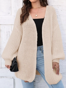Detail of chunky knit beige cardigan showing hollow-out texture and lantern sleeves