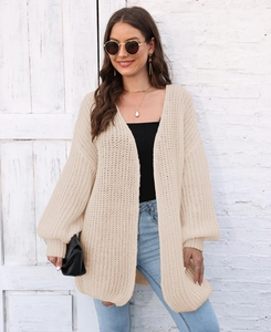 Close-up of beige chunky knit cardigan showing grid texture and puff sleeve detail